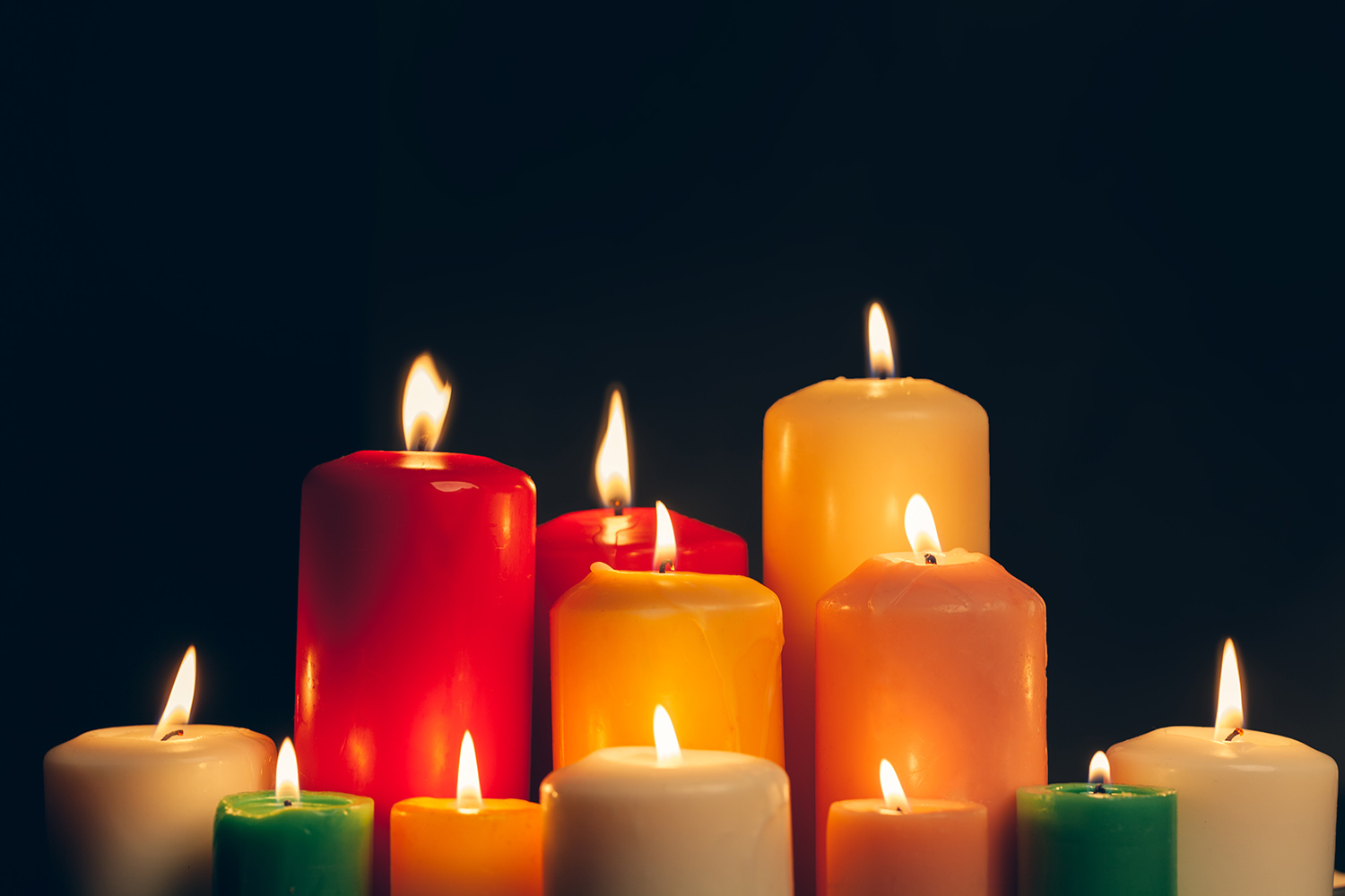candles burning in darkness over black background. commemoration concept.